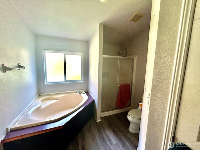 full bath featuring a garden tub, toilet, wood finished floors, visible vents, and a shower stall