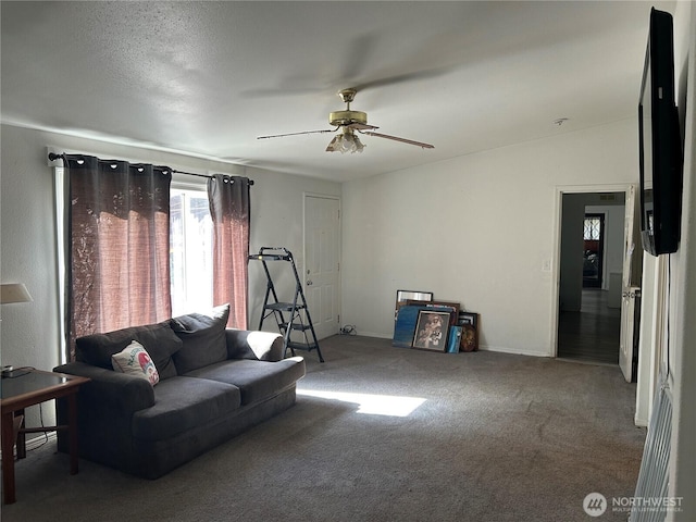 living area with carpet flooring, ceiling fan, and baseboards