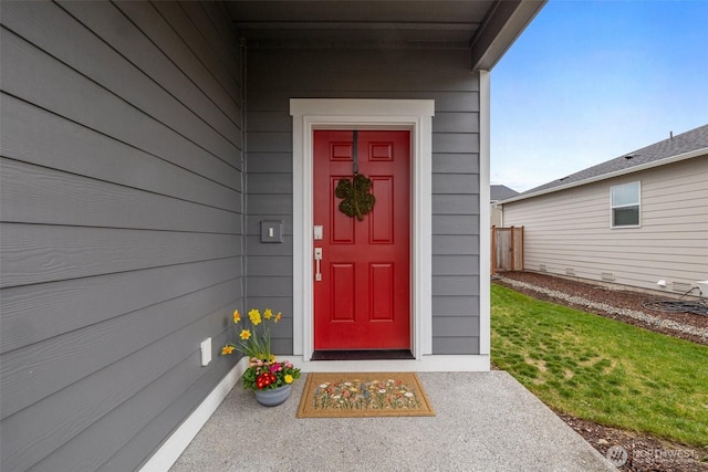 view of exterior entry with a yard