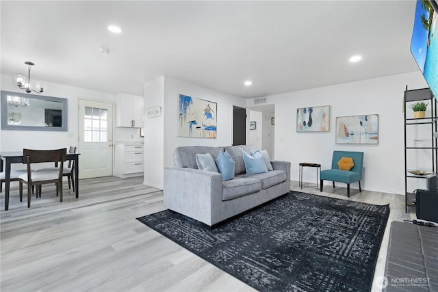 living area featuring recessed lighting, visible vents, a notable chandelier, and light wood-style flooring