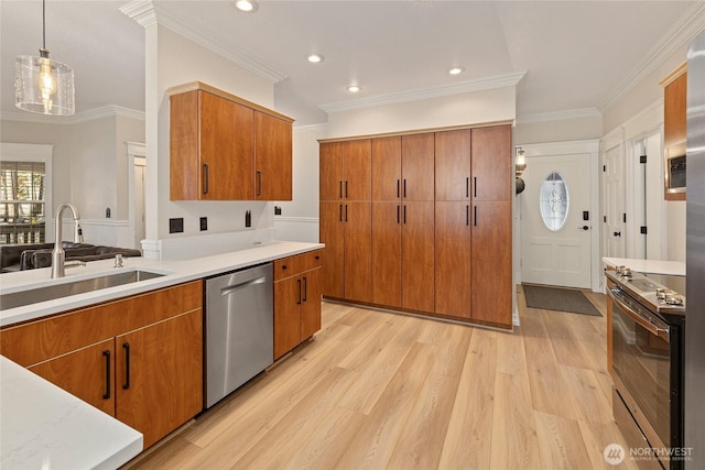 kitchen with light wood-type flooring, brown cabinets, a sink, stainless steel appliances, and light countertops