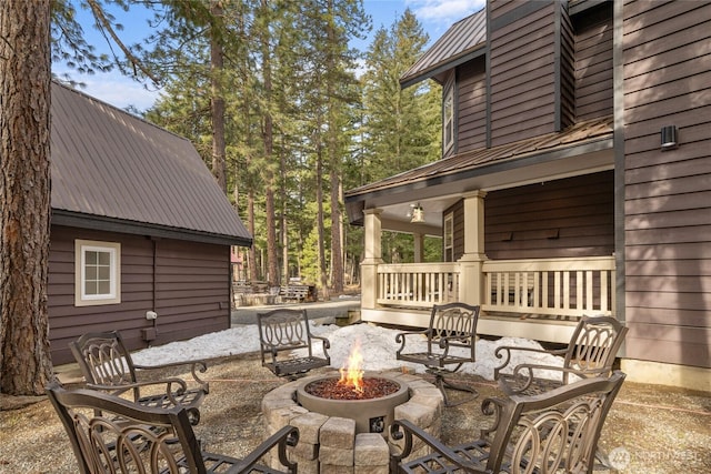 view of patio featuring covered porch and a fire pit