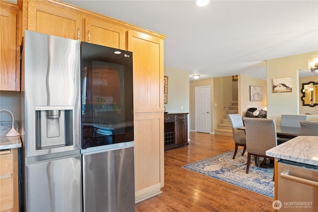 kitchen with light wood-style flooring, open floor plan, light countertops, appliances with stainless steel finishes, and light brown cabinetry