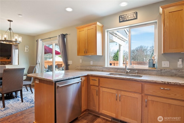 kitchen with light stone counters, a sink, a peninsula, and stainless steel dishwasher