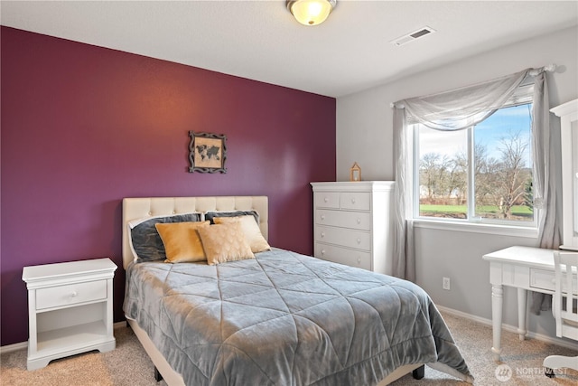 carpeted bedroom with baseboards and visible vents