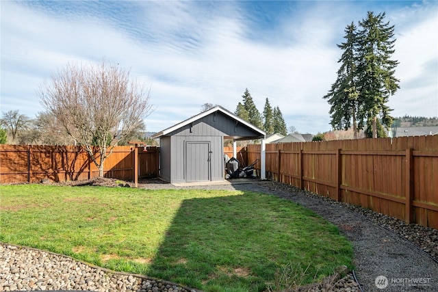 view of yard featuring a storage shed, an outdoor structure, and a fenced backyard