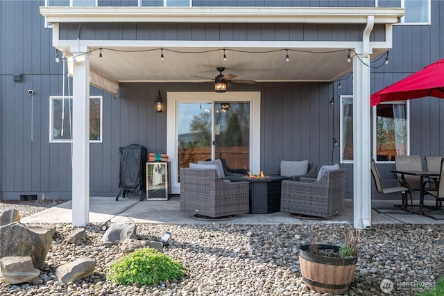 view of patio featuring a ceiling fan and an outdoor living space with a fire pit