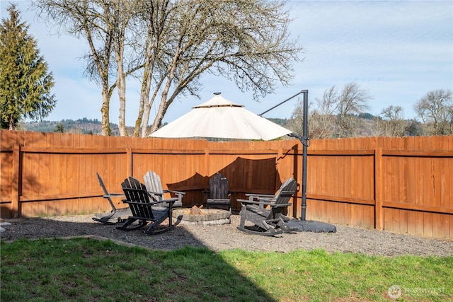 view of yard with a fire pit and fence