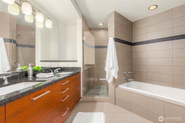 full bathroom with a stall shower, tile patterned flooring, a sink, and a relaxing tiled tub