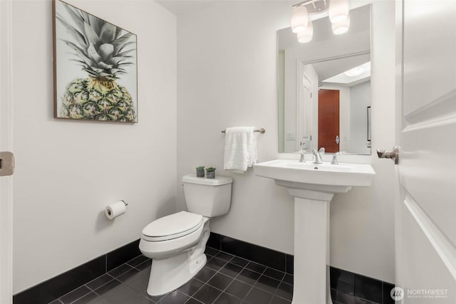 bathroom with baseboards, toilet, and tile patterned floors