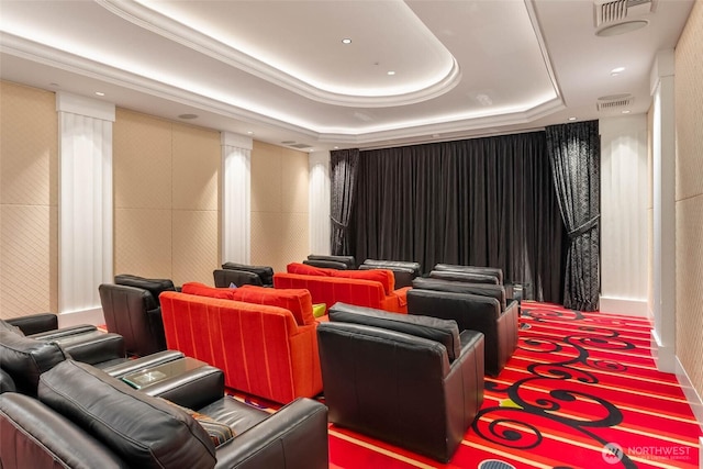 cinema room featuring visible vents and a tray ceiling