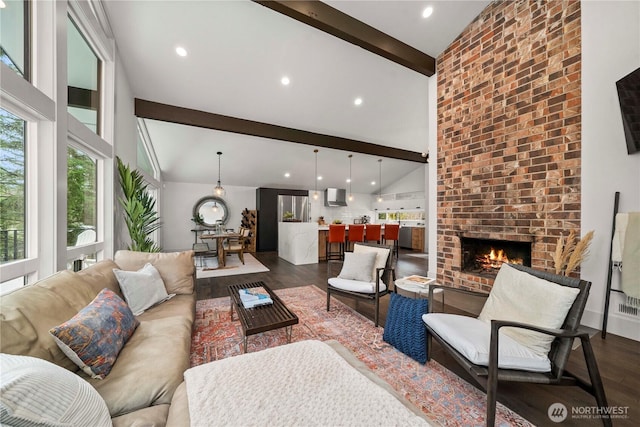 living area with high vaulted ceiling, beam ceiling, recessed lighting, dark wood-style flooring, and a brick fireplace