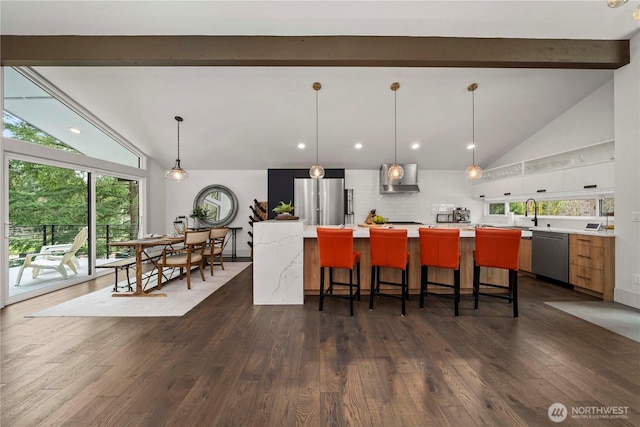 kitchen featuring beam ceiling, dark wood-style floors, appliances with stainless steel finishes, light countertops, and decorative backsplash