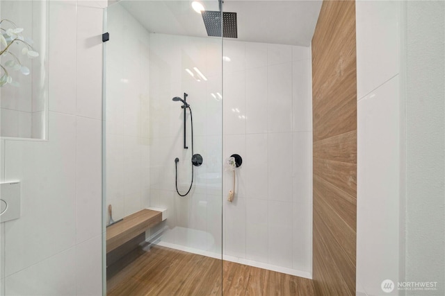 bathroom featuring tile walls, walk in shower, and wood finished floors