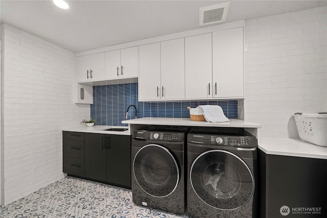 clothes washing area with visible vents, a sink, recessed lighting, cabinet space, and washing machine and clothes dryer