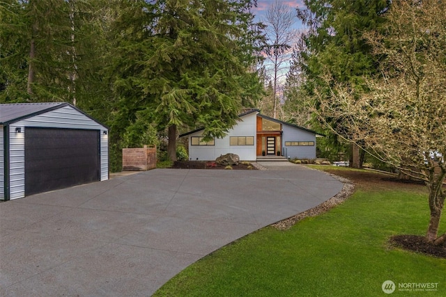 exterior space featuring a garage, an outbuilding, and a lawn