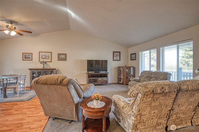 living room featuring lofted ceiling, light wood-style floors, and a ceiling fan