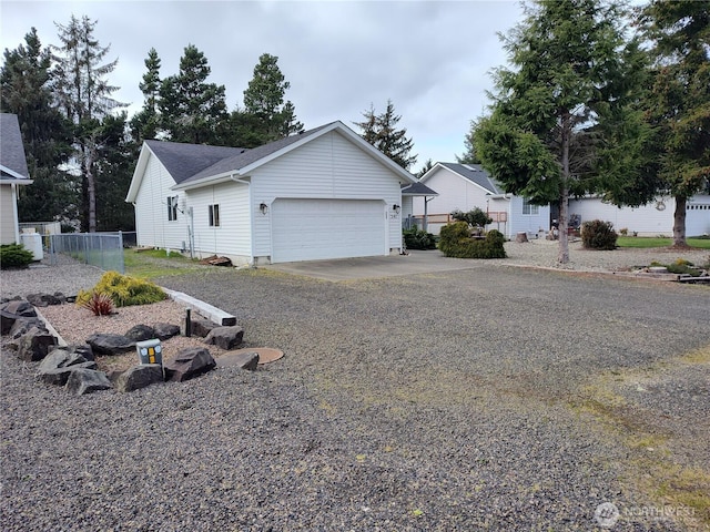 view of front of property with gravel driveway, an attached garage, and fence