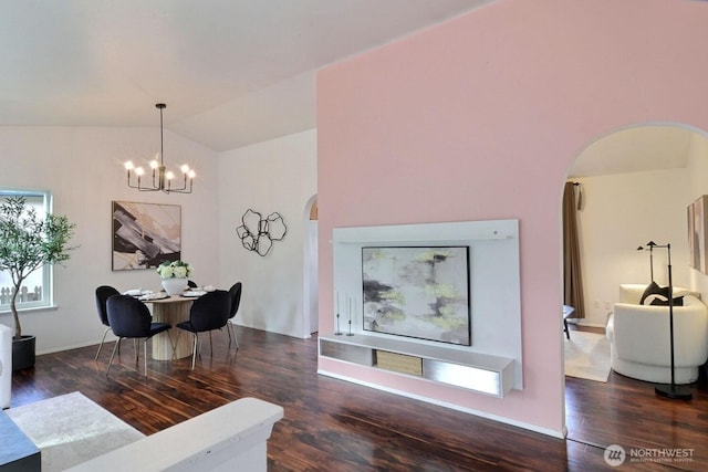 dining room with arched walkways, vaulted ceiling, wood finished floors, and an inviting chandelier