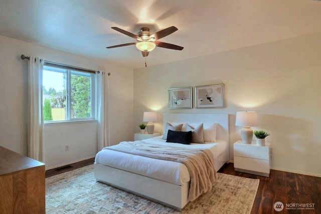 bedroom featuring visible vents, ceiling fan, baseboards, and wood finished floors