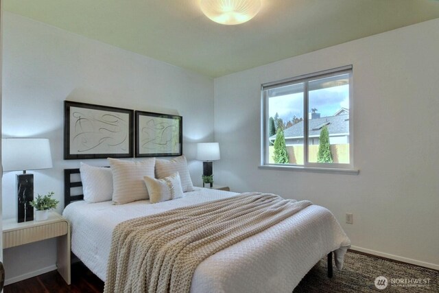 bedroom with dark wood-style floors and baseboards