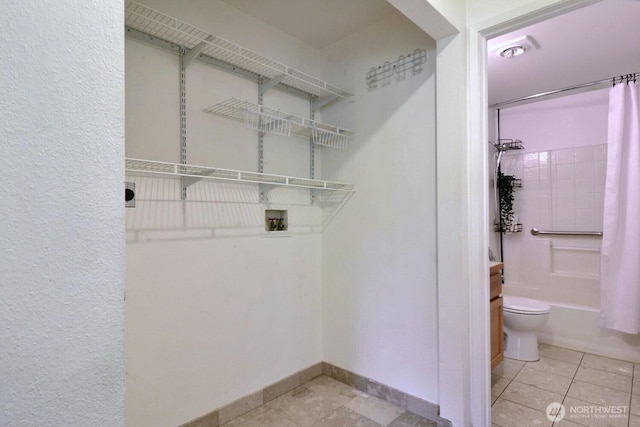 clothes washing area featuring baseboards, washer hookup, and tile patterned floors