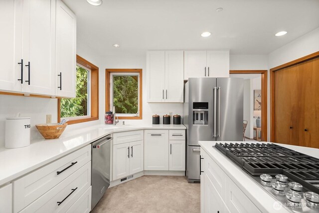 kitchen featuring white cabinets, stainless steel appliances, light countertops, and recessed lighting