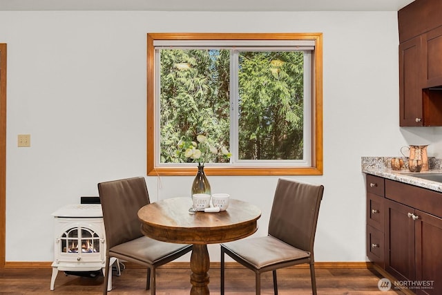 dining space featuring baseboards, wood finished floors, and a healthy amount of sunlight