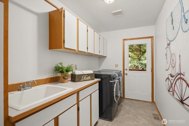 clothes washing area featuring cabinet space, visible vents, washer and clothes dryer, and a sink