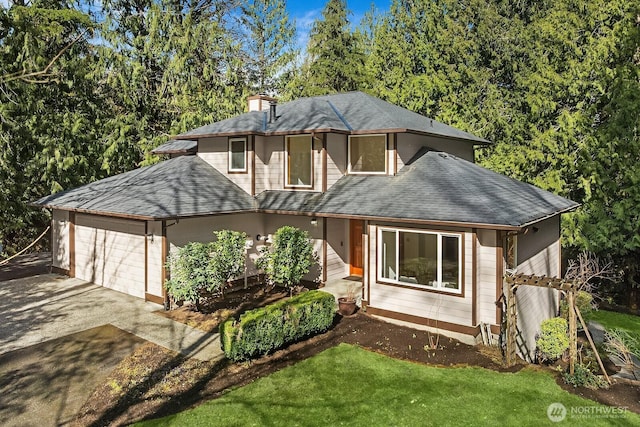 view of front of home with a garage, a shingled roof, and concrete driveway