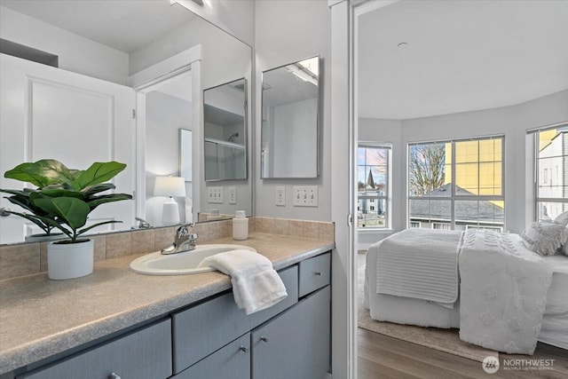 bathroom with wood finished floors, ensuite bath, and vanity