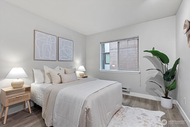 bedroom with wood finished floors, baseboards, and a baseboard radiator