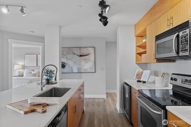 kitchen featuring light stone countertops, wine cooler, stainless steel electric range, wood finished floors, and a sink