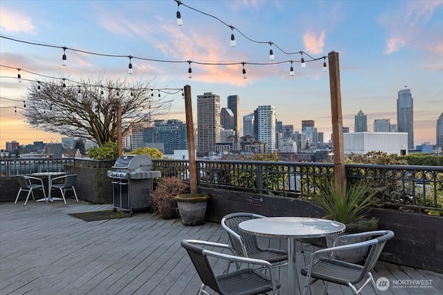 wooden deck with a city view and area for grilling