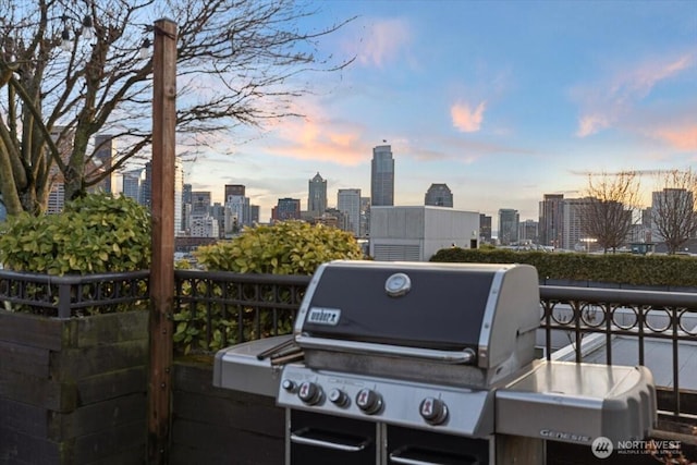 patio terrace at dusk featuring a view of city and grilling area