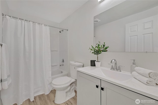 full bath featuring toilet, shower / bath combo, wood finished floors, and vanity