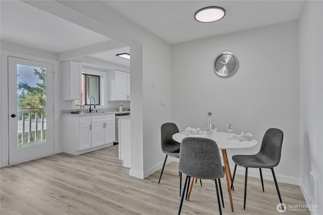 dining area featuring light wood-style flooring and baseboards