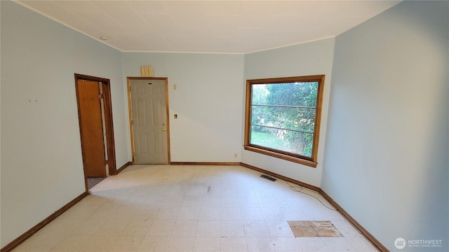 unfurnished room featuring light floors, visible vents, and baseboards