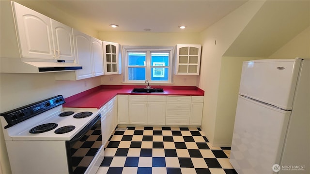 kitchen with white appliances, dark countertops, glass insert cabinets, light floors, and a sink