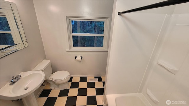 bathroom featuring baseboards, a sink, toilet, and tile patterned floors