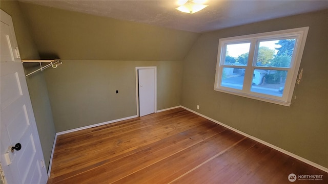 bonus room featuring lofted ceiling, baseboards, and hardwood / wood-style floors