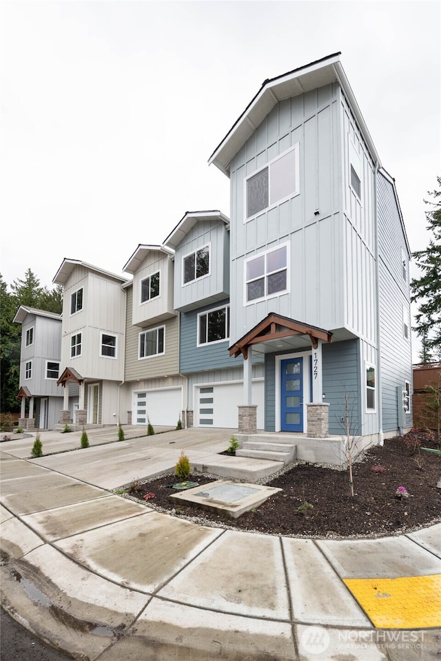 multi unit property with a garage, driveway, and board and batten siding