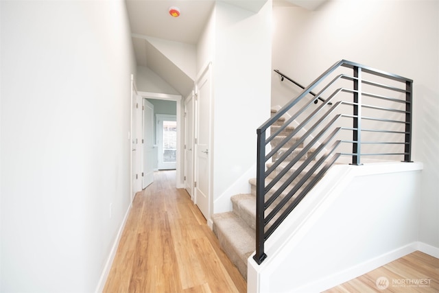 stairway with wood finished floors and baseboards