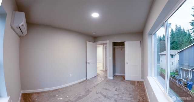 unfurnished bedroom featuring a closet, baseboards, an AC wall unit, and light colored carpet