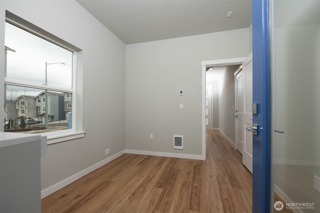 interior space with visible vents, baseboards, and wood finished floors