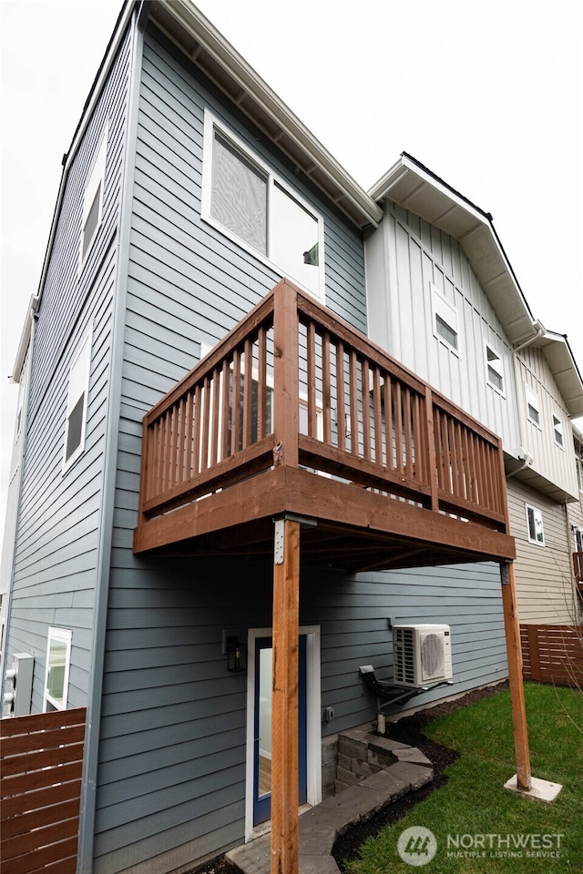 rear view of house featuring ac unit and board and batten siding