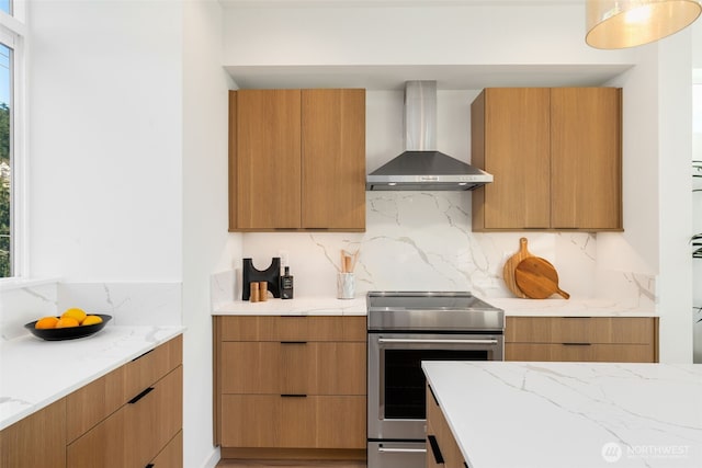 kitchen with stainless steel electric stove, modern cabinets, and wall chimney range hood