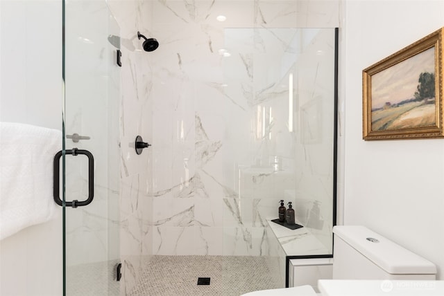 bathroom with toilet and a marble finish shower