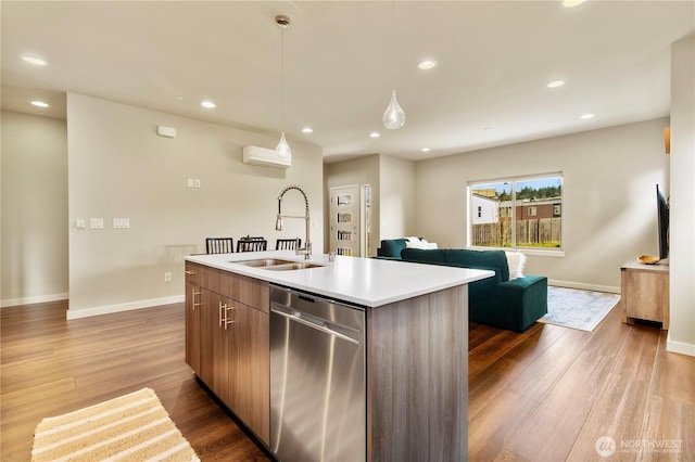 kitchen featuring dark wood-style floors, a wall unit AC, dishwasher, and a sink