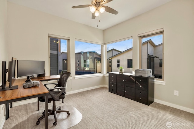 home office featuring baseboards, a ceiling fan, and light colored carpet